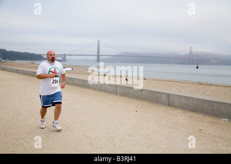 Runner sur plage près de Golden Gate Bridge Banque D'Images