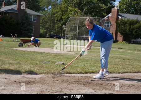 Les bénévoles construire un terrain de baseball à la maison d'enfants Banque D'Images