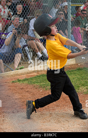 Un jeune homme se connecte avec l'entraîneur de baseball dans la petite ligue à pas variable. Banque D'Images