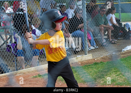 Un jeune homme se connecte avec l'entraîneur de baseball dans la petite ligue à pas variable. Banque D'Images