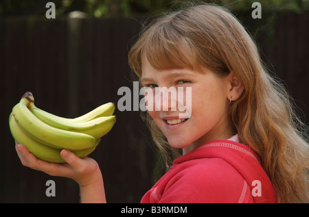 Main de bananes dans une main les jeunes filles Banque D'Images