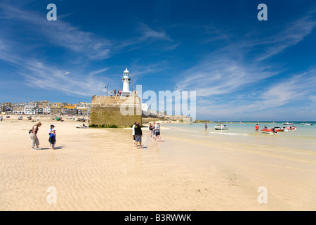 Harbour mur du port et le phare à St Ives dans le soleil d'été à marée basse à l'ouest de Cornwall Pays Angleterre Royaume-Uni Royaume-Uni GB Banque D'Images