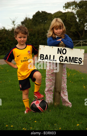 Petit garçon portant l'équipe de soccer est un kit avec aucun signe de jeux de ballon de nulle part pour jouer pour lui ou sa sœur Banque D'Images