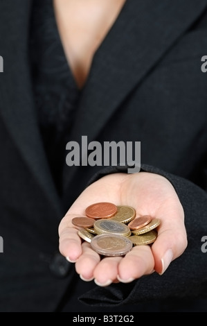 Femme tenant une poignée de pièces en euros Close Up Banque D'Images