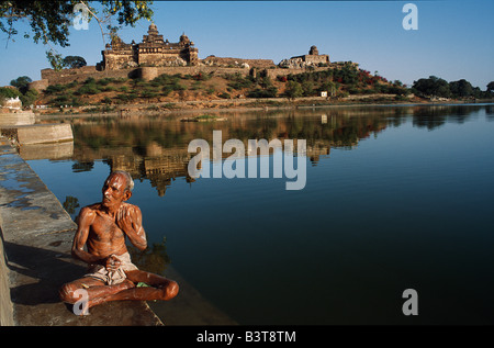 L'Inde, le Madhya Pradesh, Datia. Un homme effectuer ses ablutions dans le Concertkenya Sagar Lake surplombé par l'Impressionnant aperçu de Banque D'Images