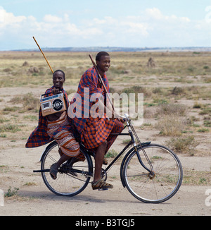 La Tanzanie, Arusha, le MTO wa Mbu. Anciens et nouveaux. Traditionnellement habillés et transportant du personnel en bois familiers, deux jeunes hommes donner des indices que le mode de vie des jeunes générations Maasai évolue progressivement en Tanzanie. Banque D'Images