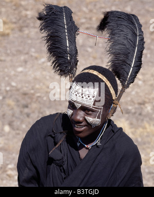 La Tanzanie, le nord de la Tanzanie, Kitumbeine. Les vêtements noirs, plumes d'autruche noir et blanc les motifs sur la face de Banque D'Images