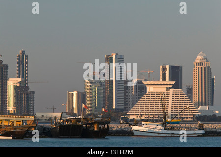 Qatar, Doha, Ad Dawhah. La baie de l'ouest de bâtiments le Dhow Harbour / Coucher de soleil Banque D'Images