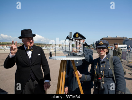 Des acteurs qui incarne le personnel de la Seconde Guerre mondiale, des officiers de la RAF et Winston Churchill debout avec un instrument de traçage de poteau. Aéroport de Shoreham, Sussex Banque D'Images