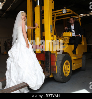 Une bride sur les fourches d'un chariot élévateur conduit par son fiancé Banque D'Images