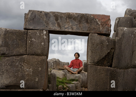 Un jeune homme médite dans les anciennes ruines Incas en dehors de Cuzco, Pérou Banque D'Images