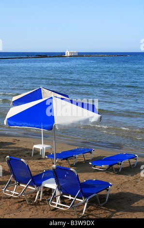 Chaises longues donnant sur l'église de pêcheurs à la fin de Georgioupolis, Crète, Grèce du nord central pier Banque D'Images