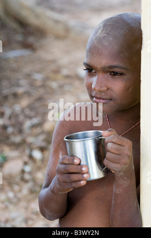 Jeune Indien avec mug métal, l'eau potable Banque D'Images