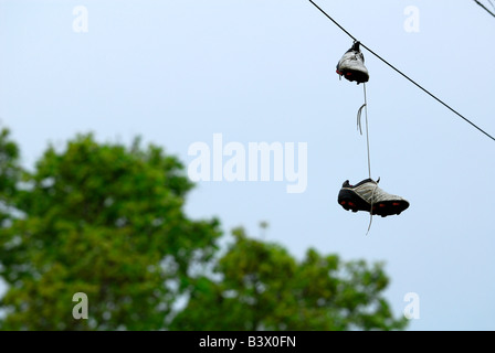 Une paire de chaussures de foot accroché sur les lignes d'alimentation Banque D'Images