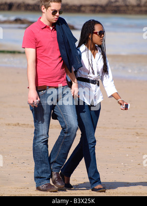 Entre 20 mixed race couple en train de marcher le long de la plage Banque D'Images