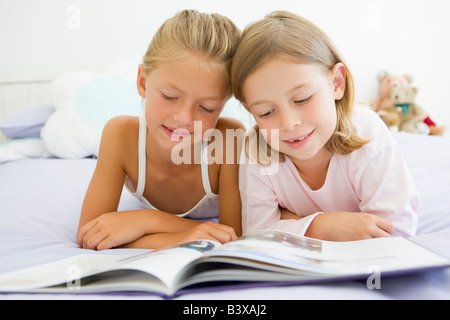 Deux jeunes filles en pyjama, lire un livre Banque D'Images