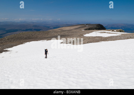 Single female hiker traverse névé à la fin du printemps près du sommet du Ben Nevis, la plus haute montagne de Britains, Lochaber, Ecosse Banque D'Images