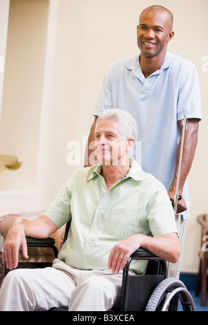 Nurse Pushing Man In Wheelchair Banque D'Images