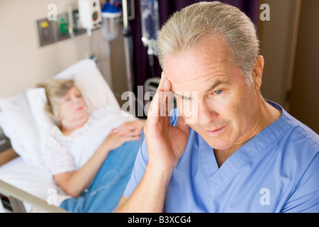 Doctor Standing in Patients Prix, à la frustration Banque D'Images