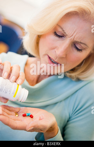 Senior Woman Pouring Pills en bouteille Banque D'Images