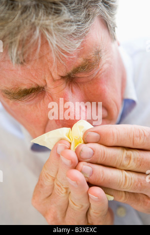 Man Blowing son nez Banque D'Images