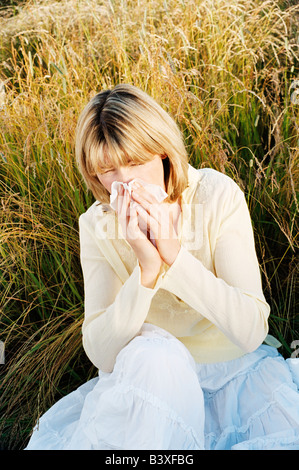 Woman Blowing son nez Banque D'Images