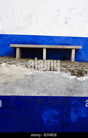 Banc de la rue et sur les murs peints dans la ville d'Obidos Portugal Banque D'Images