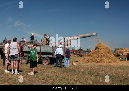 Les badauds regarder old time démonstration de battage Banque D'Images