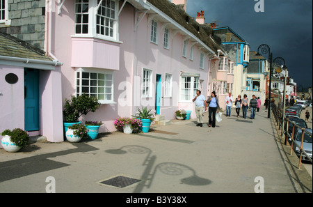 La consommation de crème glacée sur la promenade principale, avec ses lampadaires design d'ammonites à Lyme Regis, dans le Dorset, Angleterre. Banque D'Images