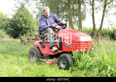 Man mowing lawn sur une tondeuse à Banque D'Images