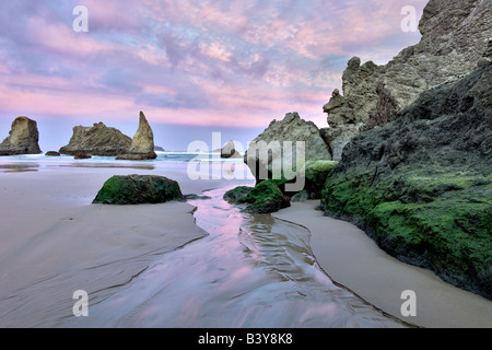 Lever du soleil sur la plage avec petit ruisseau à Bandon Oregon Banque D'Images