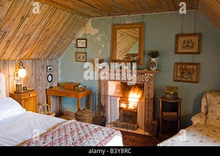 L'Écosse, Hébrides intérieures, Jura. Une cheminée incrusté coquille symbolise le chic rustique de l''une des chambres en GlenBatrick Lodge. Le lodge surplombe la plage de sable blanc du Loch Tarbert sur le côté ouest du Jura. Magnifiquement isolé le lodge est accessible uniquement par bateau ou par cinq heures de marche. Banque D'Images