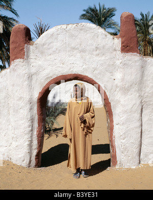 Soudan, désert du Sahara, une jeune fille se tient à l'extérieur de la porte de la paix céleste à une maison et à l'ancienne composé de Dongola. Banque D'Images