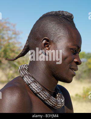 La Namibie, Kaokoland. Un jeune Himba avec son style de cheveux dans une longue natte, connu comme ondatu. Une fois marié, il va diviser le ondatu Banque D'Images