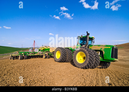 Un grand tracteur équipé d'un GPS tire perceuse à air sur les collines de la région de Palouse Washington pour planter les haricots au printemps Banque D'Images