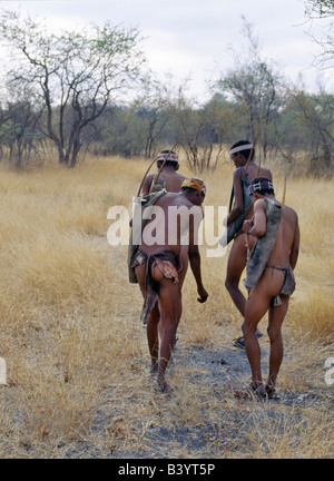 La Namibie, l'Est Bushmanland, Tsumkwe. Un petit groupe de chasseurs-cueilleurs !Kung suivre des pistes d'une antilope au début des mo Banque D'Images
