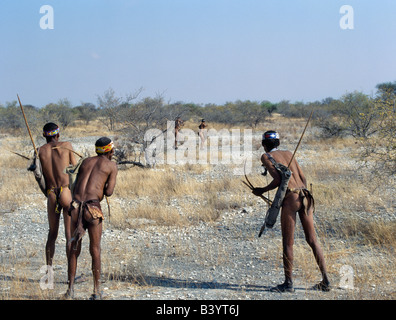 La Namibie, l'Est Bushmanland, Tsumkwe.  !Kung chasseurs-cueilleurs regarder attentivement comme un membre de leur bande, tire une flèche à un sm Banque D'Images