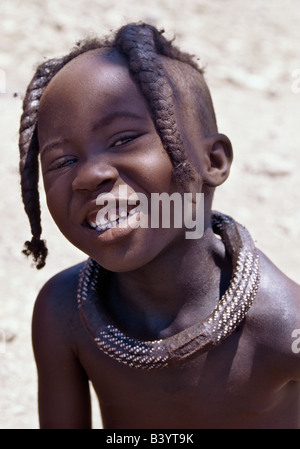 La Namibie, Damaraland, Palmwag. Une jeune fille Himba avec une coiffure tressée, qui elle portera jusqu'à l'adolescence.Les Himbas Herero Bantu francophone sont des nomades qui vivent dans les conditions difficiles, sec mais très beau paysage de la nord-ouest de la Namibie. Banque D'Images