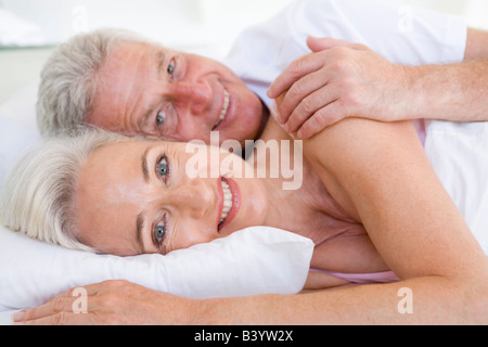 Couple Lying in Bed, smiling Banque D'Images