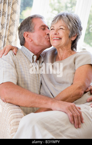 Couple relaxing in living room kissing and smiling Banque D'Images