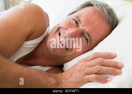 Man Lying in Bed smiling Banque D'Images