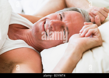 Man Lying in Bed smiling Banque D'Images