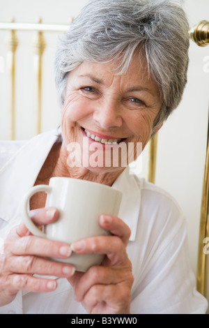 Femme dans la chambre avec café smiling Banque D'Images