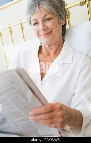 Femme de chambre avec newspaper smiling Banque D'Images