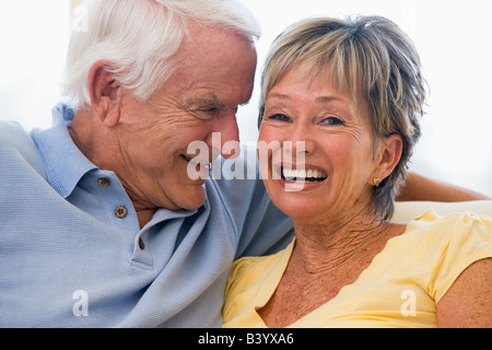 Couple relaxing in living room and smiling Banque D'Images
