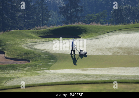 Dans les premières heures du matin, l'équipage verts préparer le Golf Club de Newcastle, Newcastle, à Washington, pour jouer. Banque D'Images