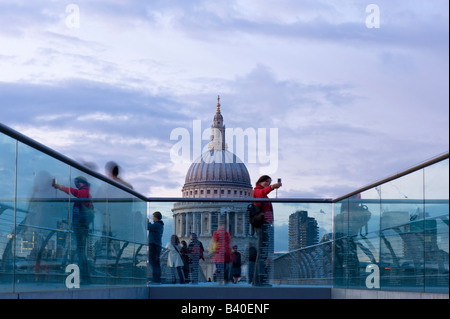 Les gens marchent à travers Millennium Bridge et Cathédrale St Paul s en arrière-plan London United Kingdom Banque D'Images