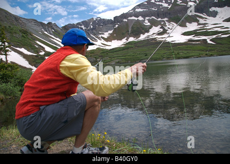 Un fishisherman jette à la mouche de la truite fardée sauvages dans un lac immaculé alpin très haut dans les montagnes de San Juan au Colorado Banque D'Images