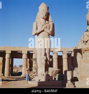 Tourist photographing statue colossale dans le Temple de Karnak, Louxor, Egypte, Afrique du Nord Banque D'Images