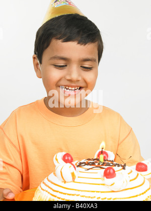 Asian boy avec gâteau, smiling Banque D'Images